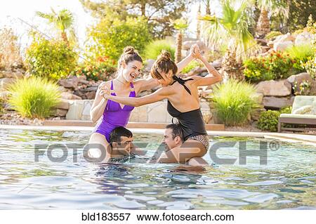 Couples playing in swimming pool View Large Photo Image Stock Photo - Couples playing in swimming pool. Fotosearch