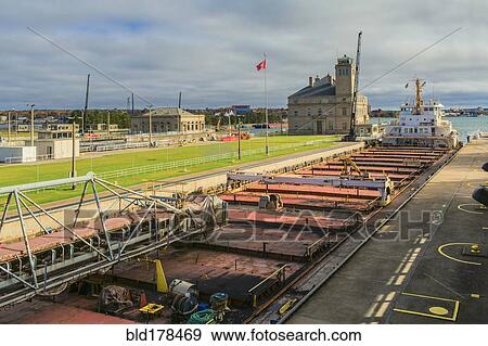 Stock Photo - Crane and shipping containers in ship yard. Fotosearch