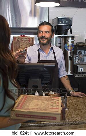 Stock Image - Customer purchasing pizza in cafe. Fotosearch