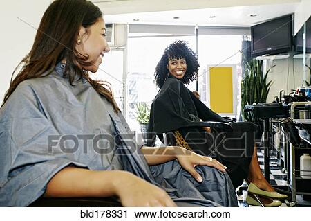 Stock Image - Customers smiling in salon. Fotosearch