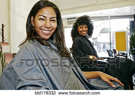 Stock Image - Customers smiling in salon. Fotosearch