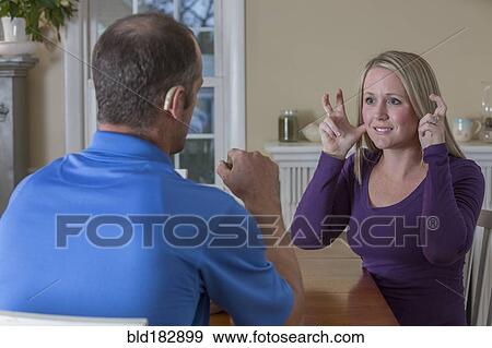 Deaf Caucasian couple signing at dinner table View Large Photo Image Stock Photo - Deaf Caucasian couple signing at dinner table. Fotosearch