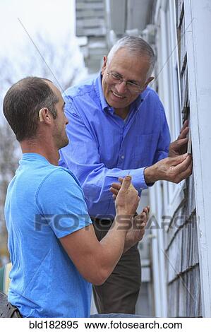 Stock Photography - Deaf Caucasian homeowner signing to repairman. Fotosearch