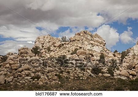Desert rock formations under cloudy sky View Large Photo Image Stock Photo - Desert rock formations under cloudy sky. Fotosearch