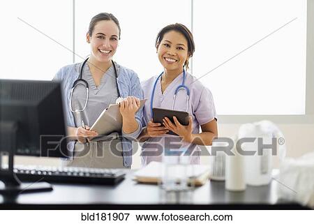 Stock Photo - Doctor and nurse smiling in hospital. Fotosearch