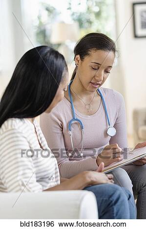 Stock Photograph - Doctor and patient talking in living room. Fotosearch