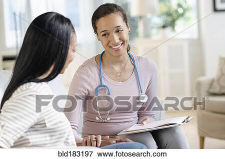 Doctor comforting patient in living room View Large Photo Image Stock Photo - Doctor comforting patient in living room. Fotosearch