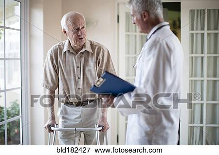 Stock Photo - Doctor talking to patient using walker. Fotosearch