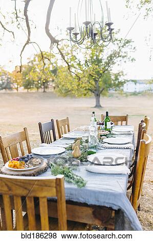 Stock Photo - Empty dinner table in field. Fotosearch
