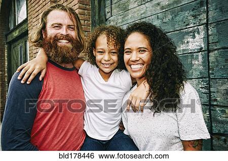 Stock Photograph - Family hugging outdoors. Fotosearch