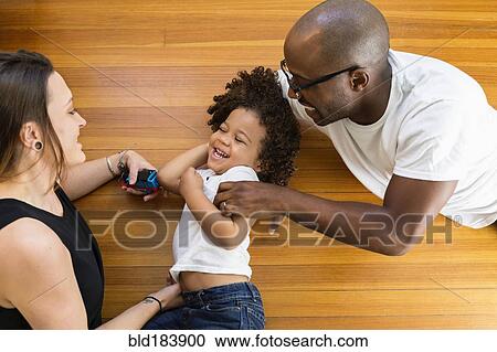 Stock Image - Family playing on floor. Fotosearch