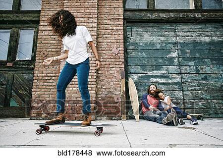 Stock Photo - Family riding skateboards on sidewalk. Fotosearch
