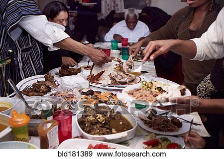 Family serving food at holiday dinner View Large Photo Image Stock Photo - Family serving food at holiday dinner. Fotosearch