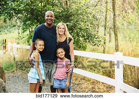 Stock Photo - Family smiling on gravel path. Fotosearch