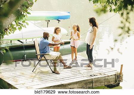 Family standing on dock in lake View Large Photo Image Stock Photo - Family standing on dock in lake. Fotosearch