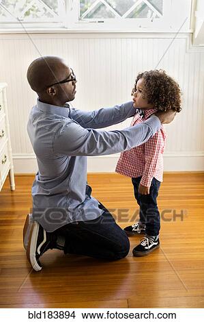 Picture - Father adjusting collar for son. Fotosearch