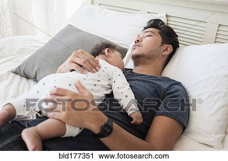 Father and baby son sleeping on bed View Large Photo Image Stock Image - Father and baby son sleeping on bed. Fotosearch