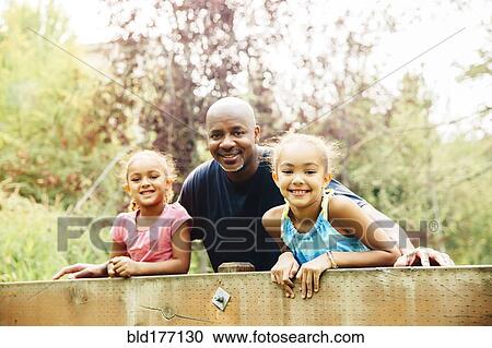 Father and daughters smiling outdoors View Large Photo Image Stock Image - Father and daughters smiling outdoors. Fotosearch