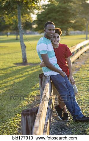 Father and son hugging at fence View Large Photo Image Stock Photo - Father and son hugging at fence. Fotosearch