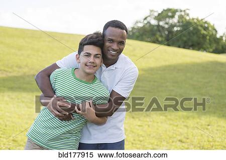 Father and son hugging in park View Large Photo Image Stock Photography - Father and son hugging in park. Fotosearch