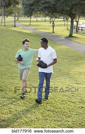 Father and son playing catch in park View Large Photo Image Stock Photograph - Father and son playing catch in park. Fotosearch