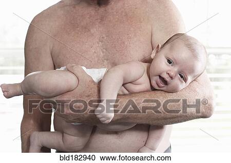 Stock Image - Father holding baby son. Fotosearch