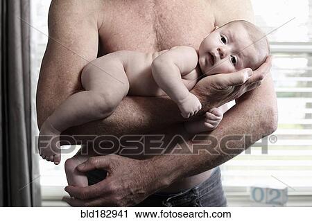 Stock Image - Father holding baby son. Fotosearch