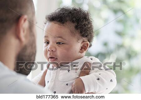Stock Photography - Father holding baby son. Fotosearch