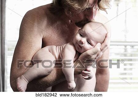 Stock Image - Father kissing baby son. Fotosearch