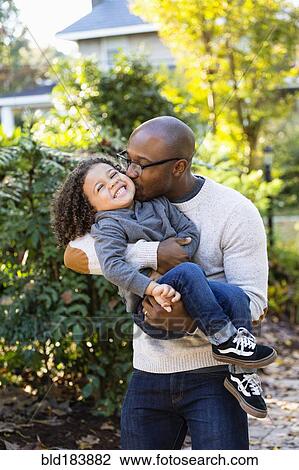 Stock Image - Father kissing son outdoors. Fotosearch