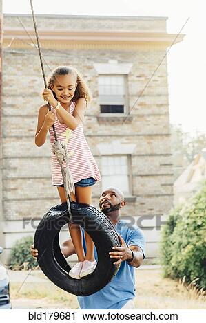 Father pushing daughter on tire swing View Large Photo Image Stock Image - Father pushing daughter on tire swing. Fotosearch