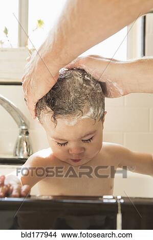 Father washing baby son in kitchen sink View Large Photo Image Picture - Father washing baby son in kitchen sink. Fotosearch