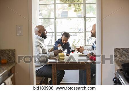 Stock Photograph - Fathers and children sitting at table. Fotosearch