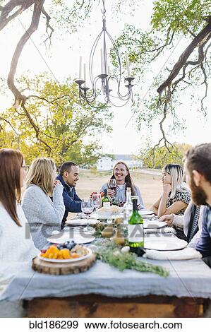 Friends drinking wine at outdoor table View Large Photo Image Stock Photo - Friends drinking wine at outdoor table. Fotosearch