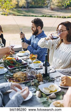 Stock Image - Friends eating at outdoor table. Fotosearch