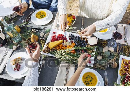 Stock Image - Friends eating at outdoor table. Fotosearch