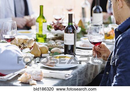 Friends eating at outdoor table View Large Photo Image Stock Image - Friends eating at outdoor table. Fotosearch