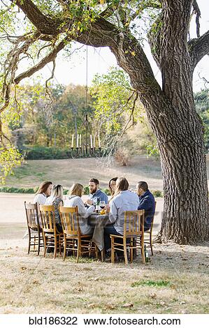 Stock Image - Friends eating at outdoor table. Fotosearch