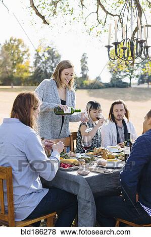 Friends eating at outdoor table View Large Photo Image Stock Photo - Friends eating at outdoor table. Fotosearch