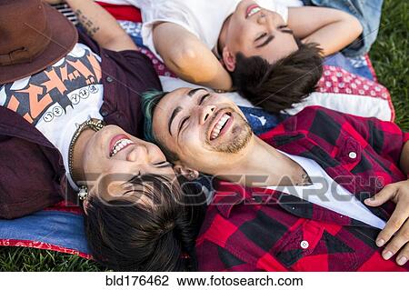 Friends laying in grass View Large Photo Image Stock Image - Friends laying in grass. Fotosearch