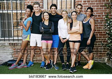 Stock Photo - Friends smiling near brick wall. Fotosearch
