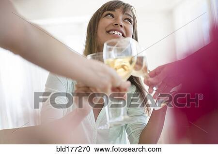 Stock Image - Friends toasting with white wine. Fotosearch