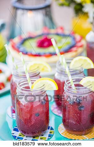 Stock Photo - Fruit juice in jars outdoors. Fotosearch