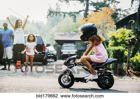 Girl riding miniature motorcycle on street View Large Photo Image Stock Image - Girl riding miniature motorcycle on street. Fotosearch