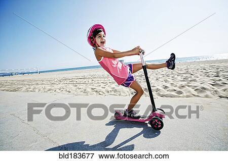 Girl riding scooter at beach View Large Photo Image Stock Photo - Girl riding scooter at beach. Fotosearch