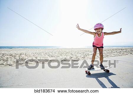 Girl riding skateboard at beach View Large Photo Image Picture - Girl riding skateboard at beach. Fotosearch