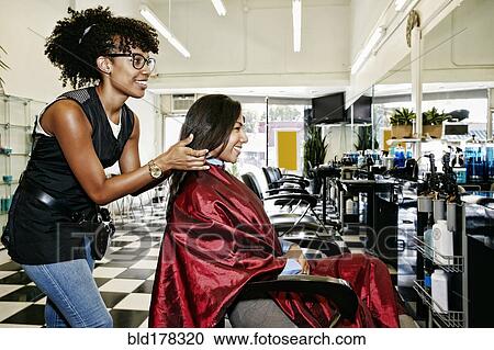 Hairstylist styling hair of customer in salon View Large Photo Image Stock Image - Hairstylist styling hair of customer in salon. Fotosearch