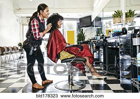 Hairstylist styling hair of customer in salon View Large Photo Image Stock Image - Hairstylist styling hair of customer in salon. Fotosearch