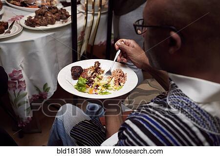 High angle view of Black man eating dinner View Large Photo Image Stock Photo - High angle view of Black man eating dinner. Fotosearch