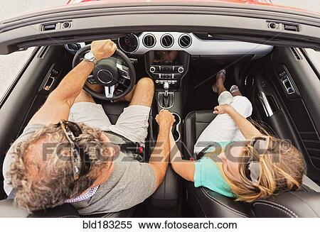Stock Photography - High angle view of Caucasian couple holding hands convertible. Fotosearch